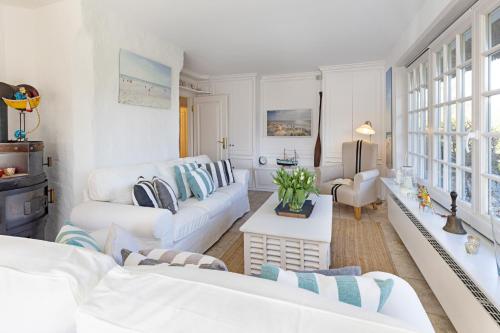 een woonkamer met witte meubels en een witte bank bij Nordmeer in List