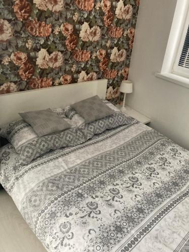 a bedroom with a bed with a floral wall at Apartament Sobieskiego in Zabrze