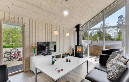 uma sala de estar com uma mesa branca e uma televisão em Nice Home In Nrre Nebel With Kitchen em Lønne Hede