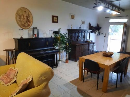 a living room with a table and a piano at Villa mendola in Cianciana