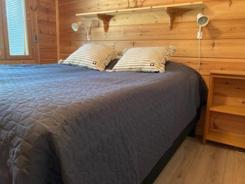 Kivilahtiにあるlomahuvila kultahiekka holiday villa golden sandの木製の壁のベッドルーム1室(大型ベッド1台付)