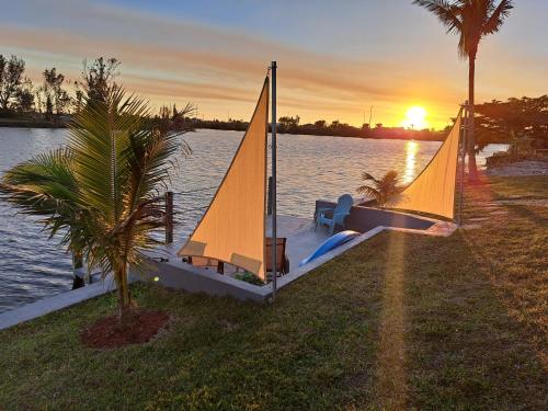 a small sail boat on the water at sunset at Wildlife Views & Fishing Villa in Cape Coral