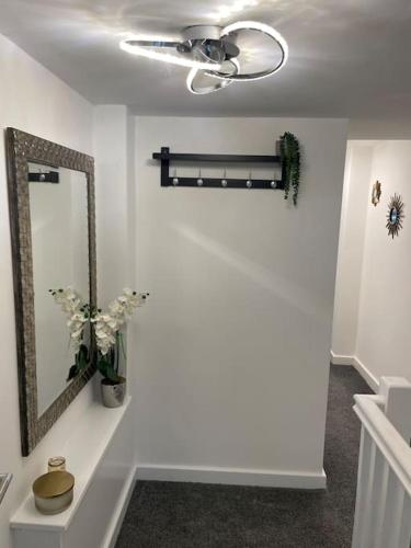 a bathroom with a mirror and a ceiling fan at Luxury Town Center Studio Stevenage in Stevenage