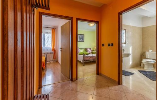 an orange hallway with a bathroom with a toilet at Lovely Home In Sisan With Outdoor Swimming Pool in Šišan