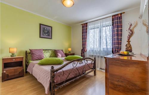 a bedroom with a bed with green walls and a window at Lovely Home In Sisan With Outdoor Swimming Pool in Šišan