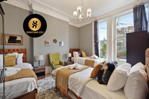 um quarto de hotel com três camas e uma janela em 2 Bedroom Apt at Sensational Stay Serviced Accommodation - Kilburn High Road em Londres