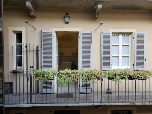 uma varanda com flores e persianas numa casa em Gallina Apartment em Bra