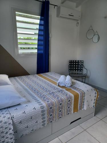a bedroom with a bed with two towels on it at Nature & Zénitude - Morne-à-l'Eau 