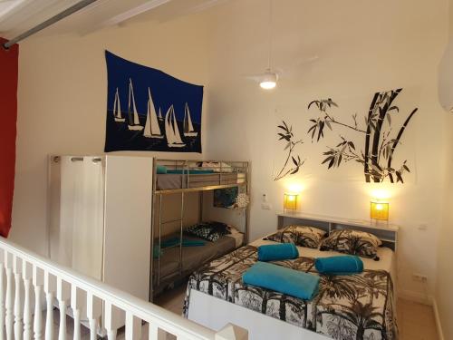 a bedroom with a bunk bed with blue pillows at appartement KER-EOL Sainte-Anne avec piscine in Sainte-Anne