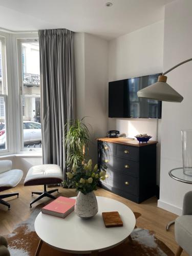 a living room with a table and a tv at Salt Life Contemporary Apartment in Brighton & Hove