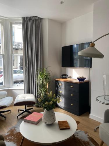 a living room with a table and a tv at Contemporary Residence by Salt Life in Brighton & Hove