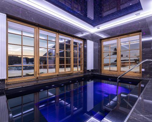 a swimming pool in a room with windows at Апарт-Готель "Панщина" in Slavske