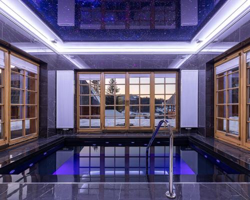 uma piscina num quarto com janelas em Апарт-Готель "Панщина" em Slavske