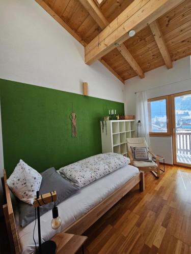 a bedroom with a bed and a green wall at Chalet Steinernes Meer in Maria Alm am Steinernen Meer