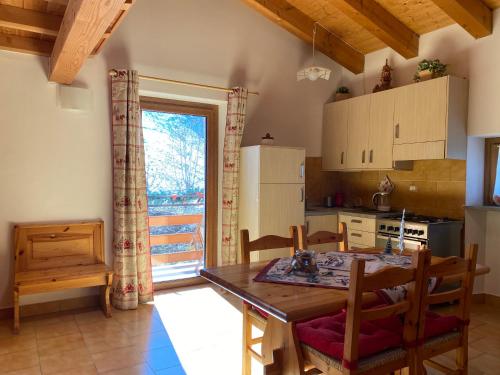 a kitchen and dining room with a table and chairs at Fleurs De Neige in Pila