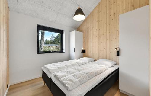 een groot bed in een kamer met een raam bij Nice Home In Blvand With Kitchen in Blåvand