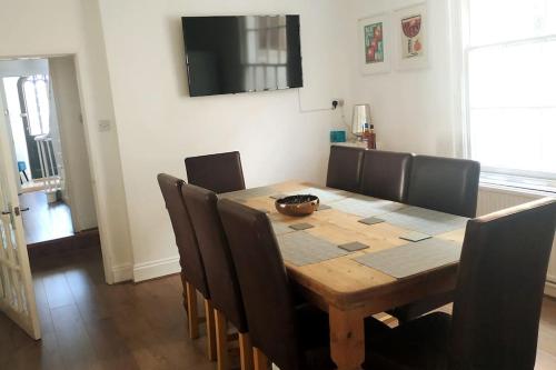 a dining room table with chairs and a television at Huge 5 bed Grade II listed home in heart of town in Exmouth