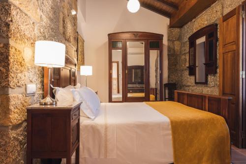 a bedroom with a bed and a table with lamps at Quinta do Outeiro in Resende