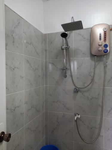 a shower with a shower head in a bathroom at Happy bear moalboal budget rooms in Moalboal