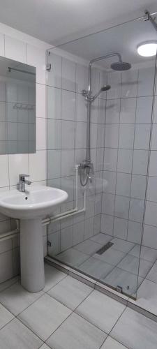 ein Bad mit einer Dusche, einem Waschbecken und einer Dusche in der Unterkunft Barlos XVIII in Buxoro