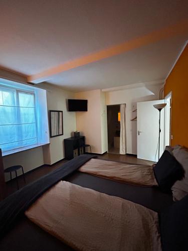 sypialnia z dużym łóżkiem i dużym oknem w obiekcie Charming Room in the heart of Locarno w mieście Locarno