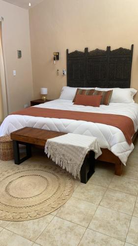 a bedroom with two beds and a wooden headboard at Beachfront apartment with swimming pool. One bedroom in Celestún