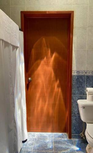 a wooden door in a bathroom with a toilet at Beachfront apartment with swimming pool. One bedroom in Celestún