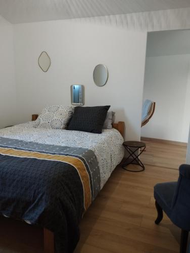 une chambre avec un lit et une chaise bleue dans l'établissement L'ATELIER DES REVES (gites des oliviers), à La Roque-sur-Cèze