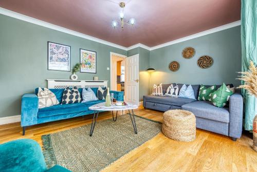 a living room with blue couches and a table at Pheasant House by Apricity Property - 5 bedrooms, 2 Bathrooms and a WC, Foosball table, free parking, Garden, Workspace in Cirencester