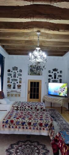 a bedroom with a large bed and a chandelier at Barlos XVIII in Bukhara