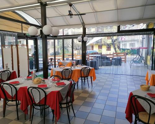 een eetkamer met tafels en stoelen met oranje tafelkleed bij HOTEL RISTORANTE DELLE VALLI in Germagnano