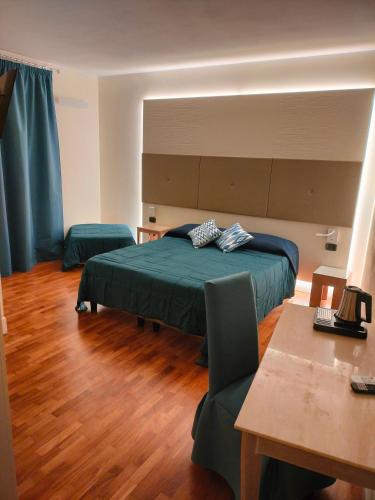 a bedroom with a green bed and a table and a table sidx sidx at Locanda La Lucciola in Portovenere