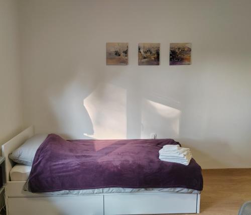 Habitación blanca con cama con sábanas moradas. en Apartment Una en Bjelovar