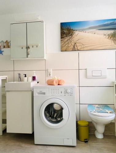 a bathroom with a washing machine and a toilet at Apartment Glesch in Bergheim