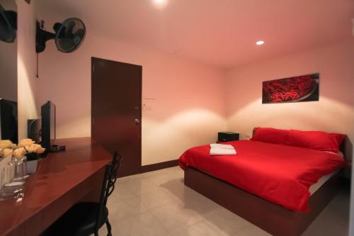 1 dormitorio con cama roja y escritorio en Walking Street Guest House en Pattaya South