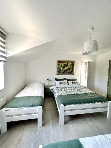 2 Betten in einem Schlafzimmer mit weißen Wänden in der Unterkunft Lux Apartments Minja in Pale