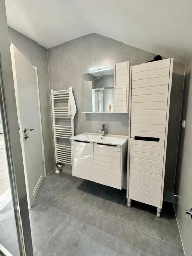 a white bathroom with a sink and a mirror at Lux Apartments Minja in Pale