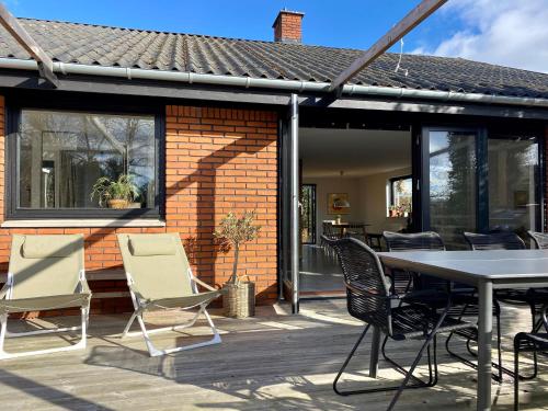 a patio with a table and chairs on it at Cheerful house, close to lakes in Farum