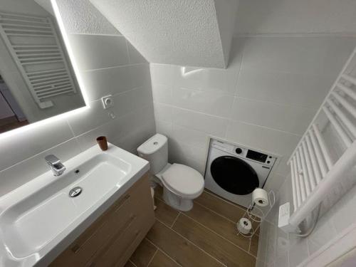 Baño blanco con aseo y lavamanos en Duplex à Pramousquier - Vue mer en Le Lavandou