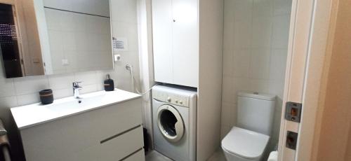 a bathroom with a washing machine and a sink at Playa in Miami Platja
