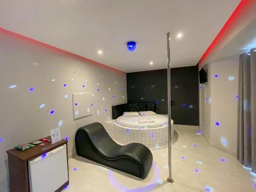 Motel Gold في تاغاتينغا: غرفة مع سرير في غرفة مع أضواء على الحائط