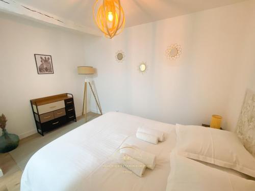 sypialnia z dużym białym łóżkiem z 2 poduszkami w obiekcie Le Cocon de Saint Arnoult w mieście Saint-Arnoult-en-Yvelines