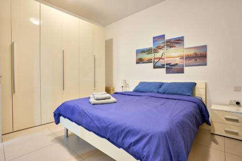 ein Schlafzimmer mit einem großen Bett mit violetter Bettwäsche in der Unterkunft Depiro Point Sliema Luxury Apartment in Sliema