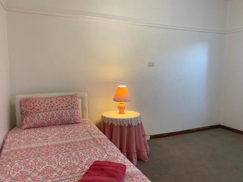 a bedroom with a bed and a lamp on a table at 6 Beds-Whole House with 4 bedrooms -Stawell - share accommodation - 2 rooms for 4 gusts are available in Stawell