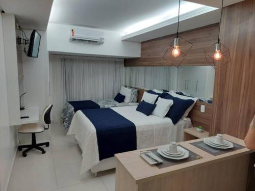 若昂佩索阿的住宿－Tambaú Flat Belo Mar - Cabo Branco - ANÚNCIO NOVO，酒店客房配有一张床和一张桌子