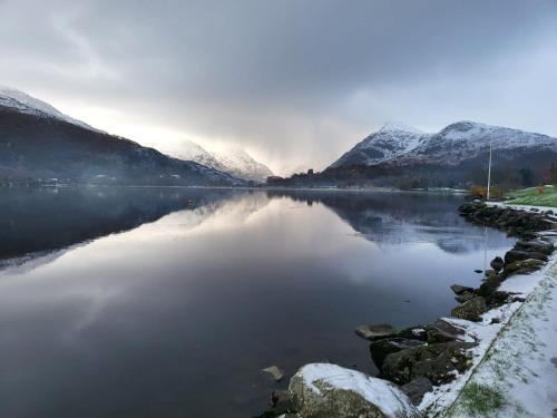 a view of a lake with snow covered mountains at Meirionfa base for Snowdon in Llanberis