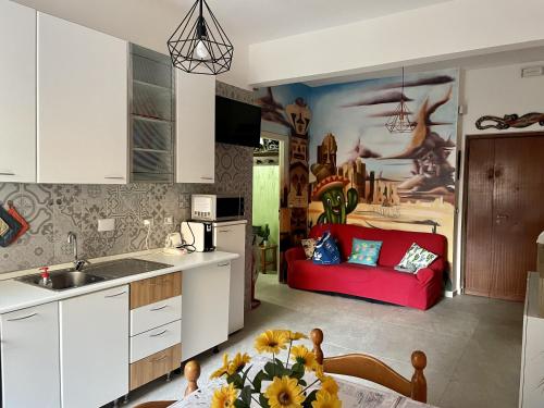 eine Küche und ein Wohnzimmer mit einem roten Sofa in der Unterkunft B&B Amigos in Lido di Ostia