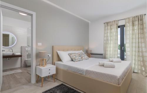 - une chambre blanche avec un grand lit et une salle de bains dans l'établissement 3 Bedroom Amazing Home In Veli Jezenj, à Veli Ježenj