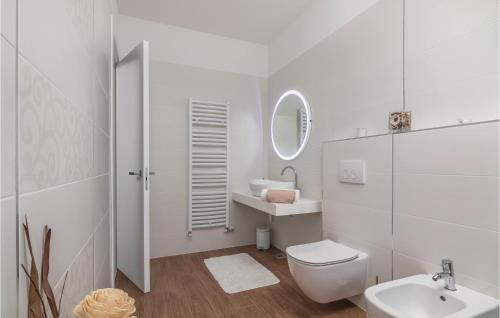 La salle de bains blanche est pourvue de toilettes et d'un lavabo. dans l'établissement 3 Bedroom Amazing Home In Veli Jezenj, à Veli Ježenj