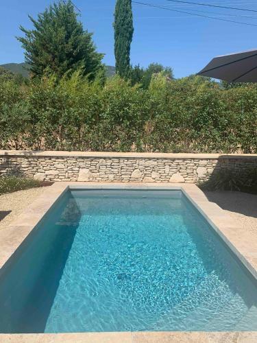 a swimming pool with blue water in a yard at Le Cabanon de Livia avec piscine privée in Cucuron